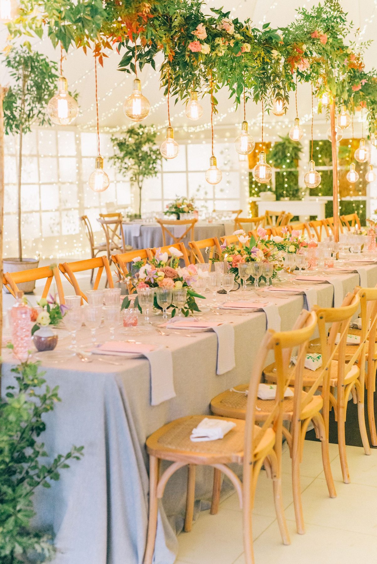 Wedding reception tables with flowers and warm overhead lights