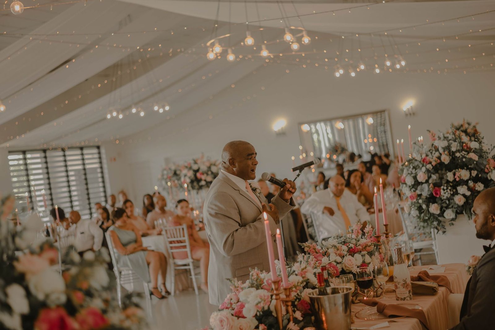 A speaker addressing wedding guests at their tables